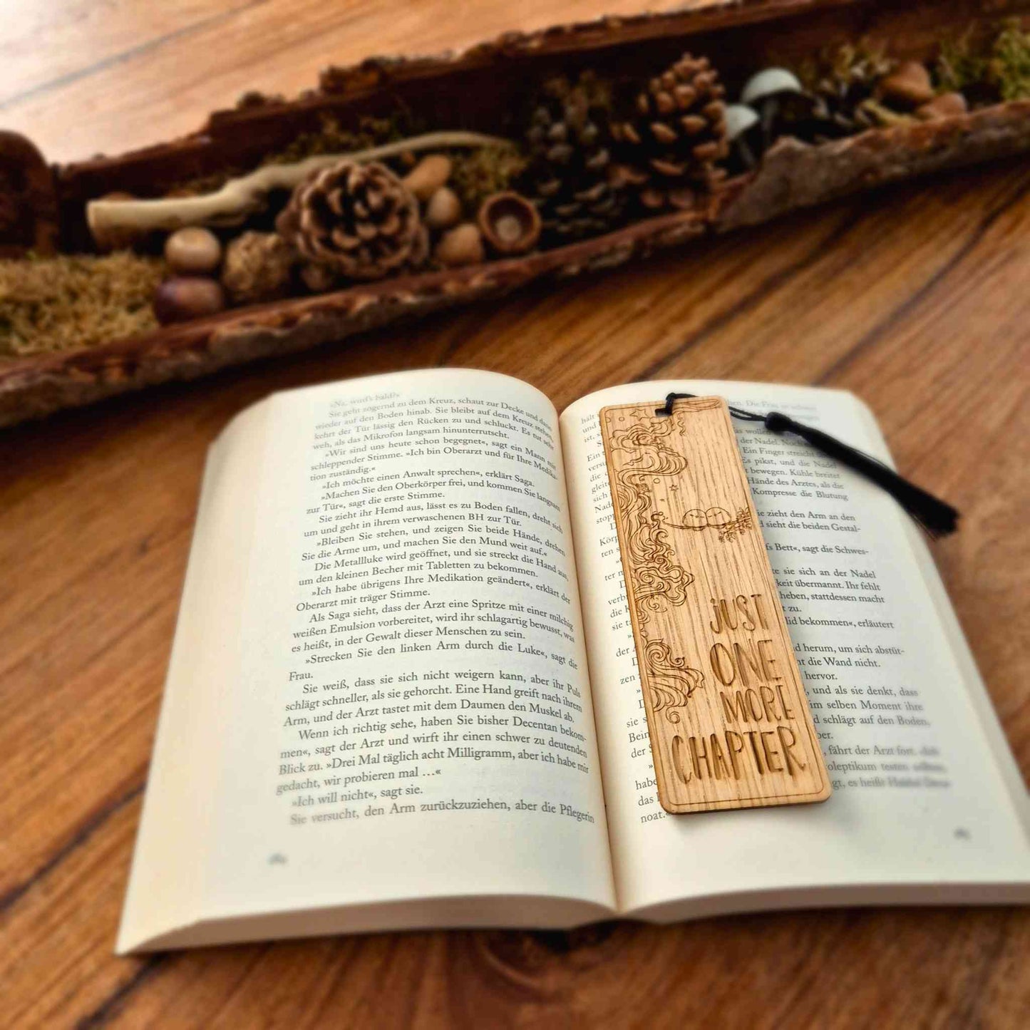 Lesezeichen aus Eichenholz mit einer Lasergravur und einem Motiv sowie dem Spruch: Just One more chapter