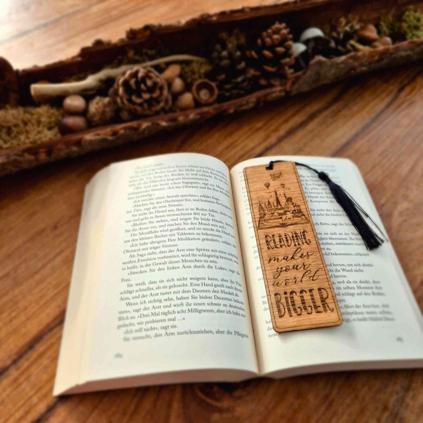 Lesezeichen aus Eichenholz mit einer Lasergravur und dem Spruch: Reading makes your world bigger