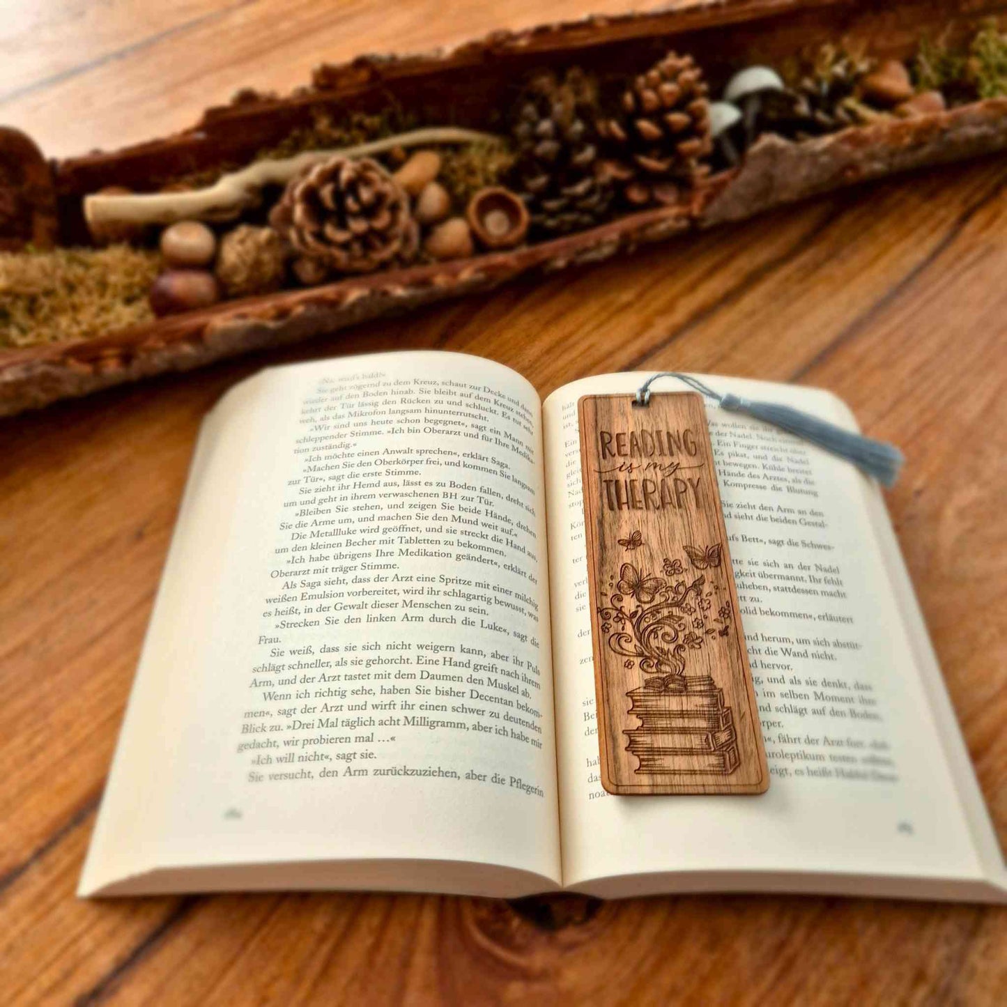 Lesezeichen aus Nussbaum mit einer Motivgravur und dem Spruch: Reading is my therapy