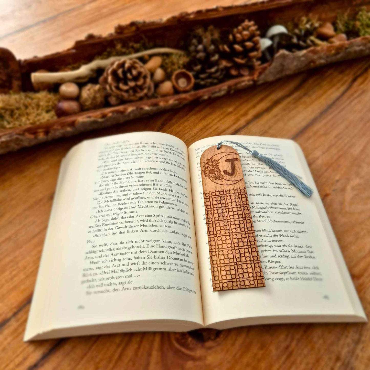 Lesezeichen aus Nussbaum mit gravierten Initialen, einem Blumenmotiv  und geometrischen Formen