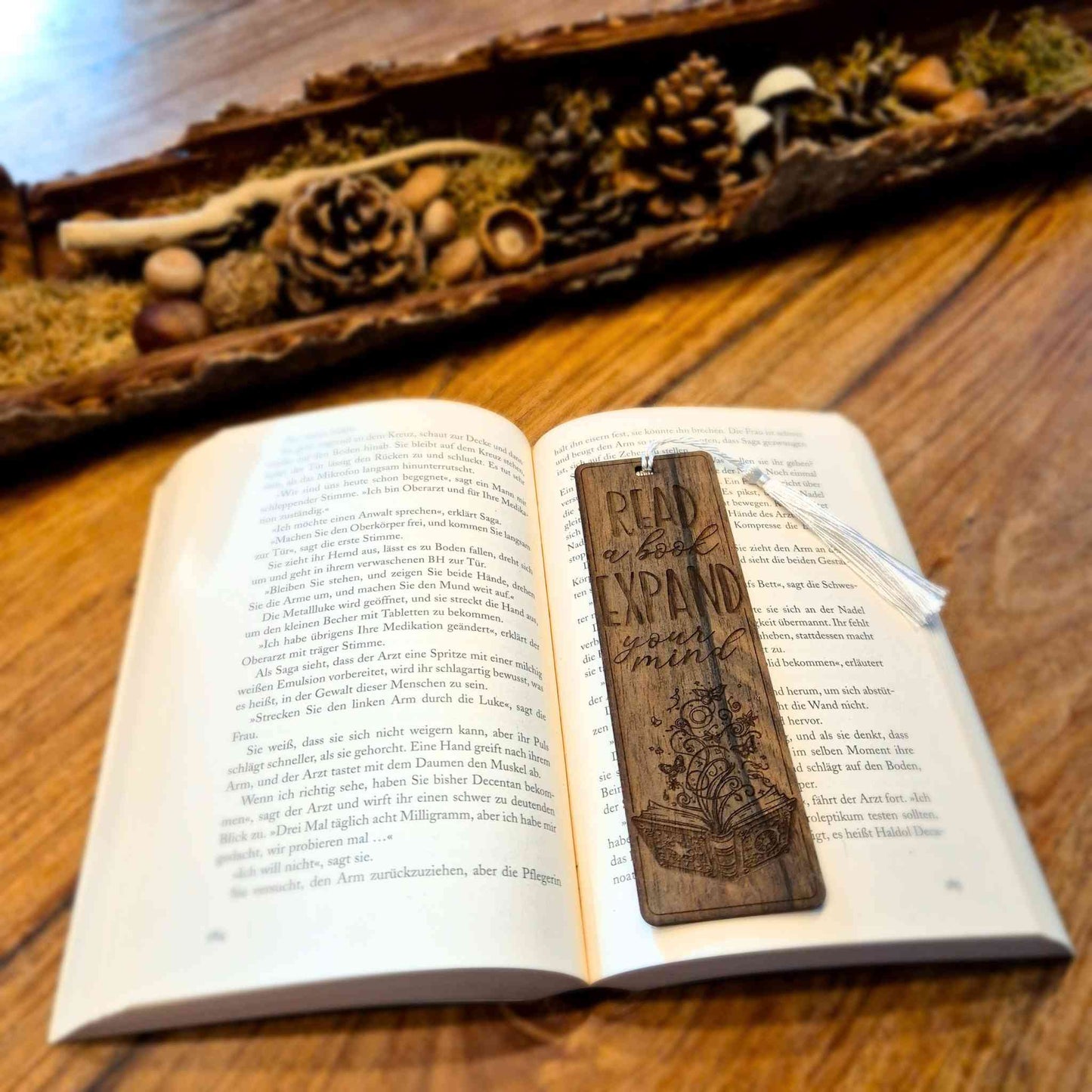 Lesezeichen aus Ziricoteholz mit einem gravierten Motiv und dem Spruch: Read a book expand your mind